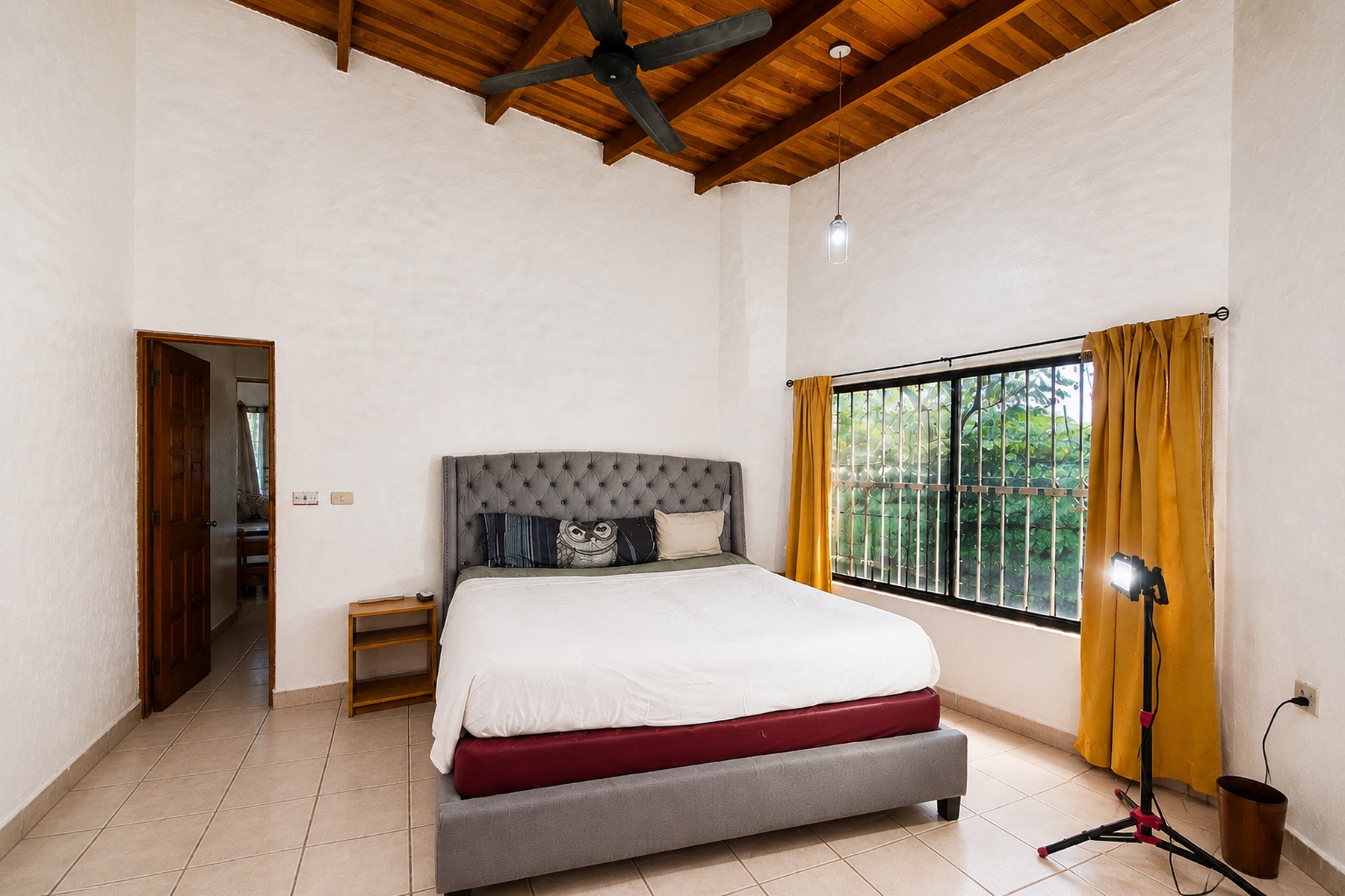 Bedroom with a high wood ceiling and garden view