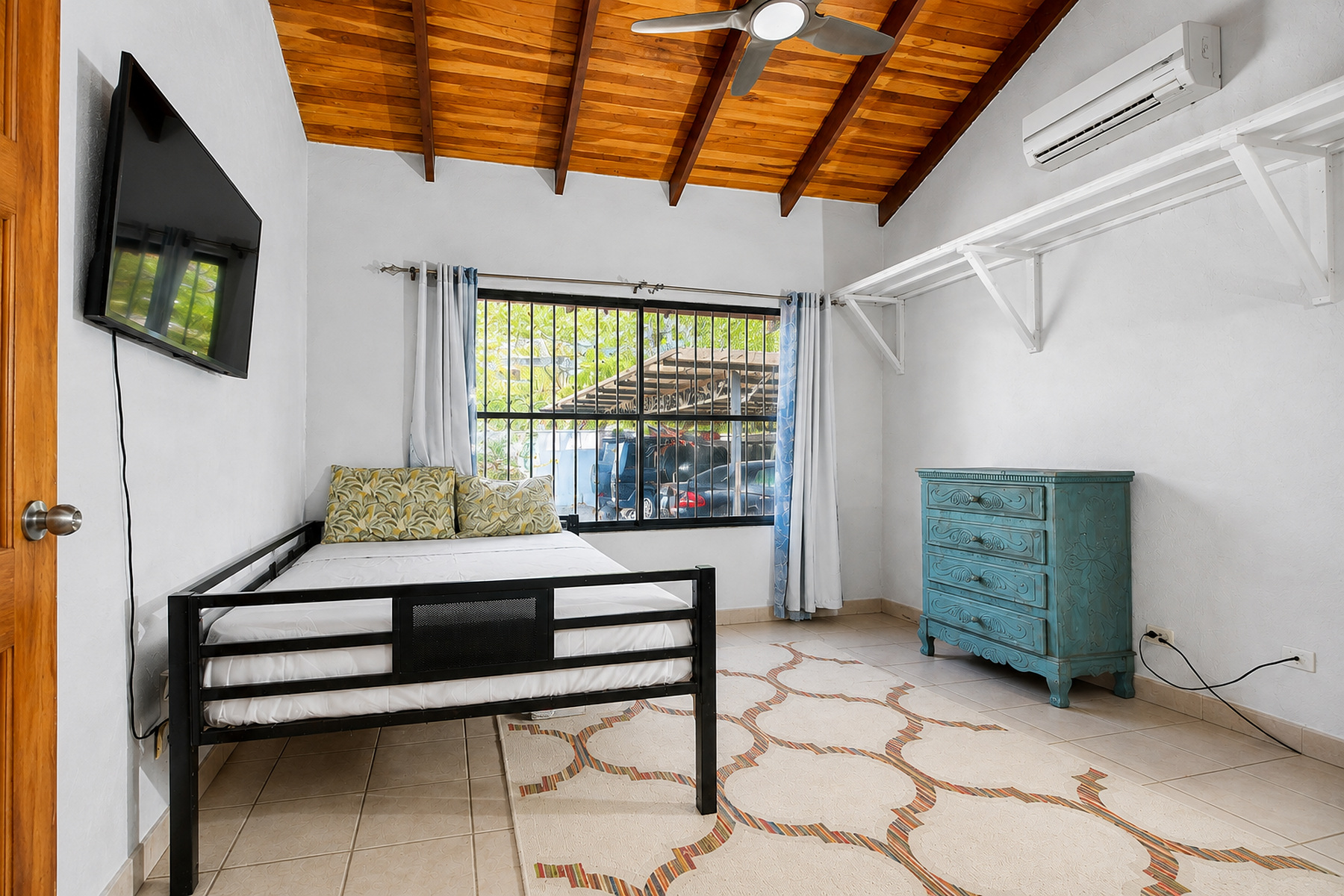 Guest bedroom under a vaulted wood ceiling